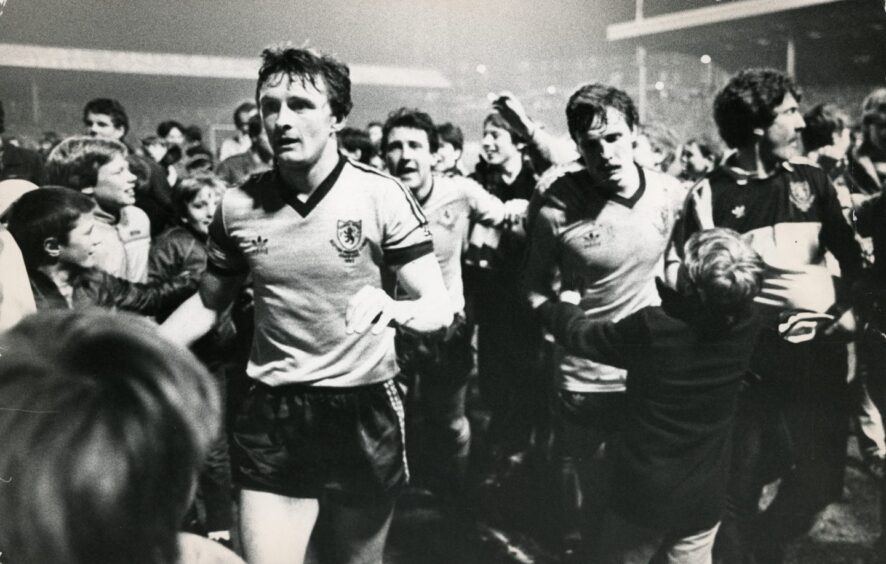 The Dundee United players are mobbed by the fans as they try to leave the Tannadice pitch after the Rapid Vienna game