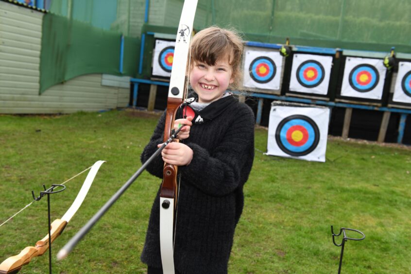 Marcy McAuslan with her bow and arrow.