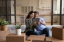 couple holds a tablet in their new house as they look at home improvement ideas