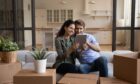 couple holds a tablet in their new house as they look at home improvement ideas