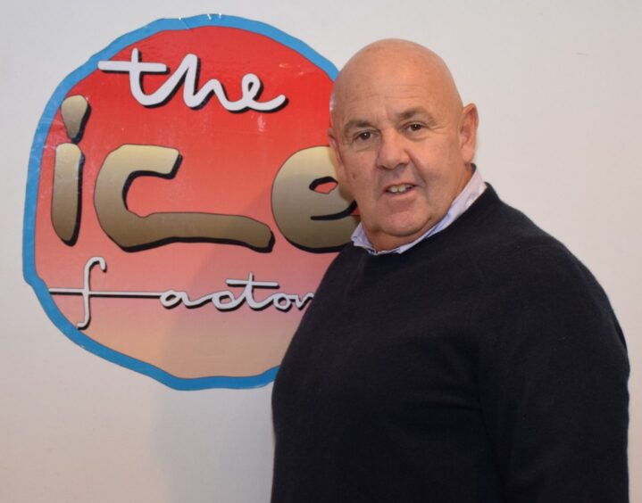Businessman John Bryden standing in front of an ice Factory logo