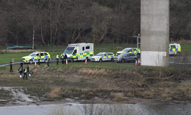 Multiple police vehicles and an ambulance beneath the Friarton Bridge in Perth
