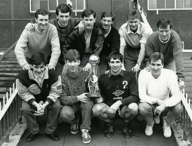 Dundee FC players celebrate the Tennent's Sixes win by displaying the trophy back at Dens Park. 