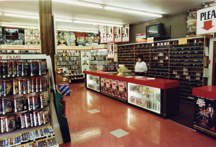 A staff member behind the counter at Cherry Video shop in Lochee in 1992.