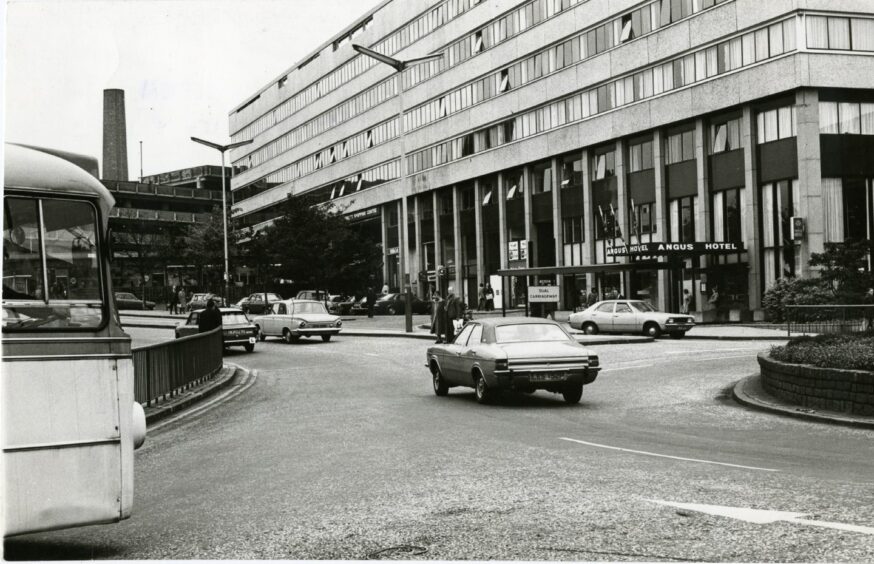 A roundabout in the foreground with The Angus Hotel in the background in 1976 