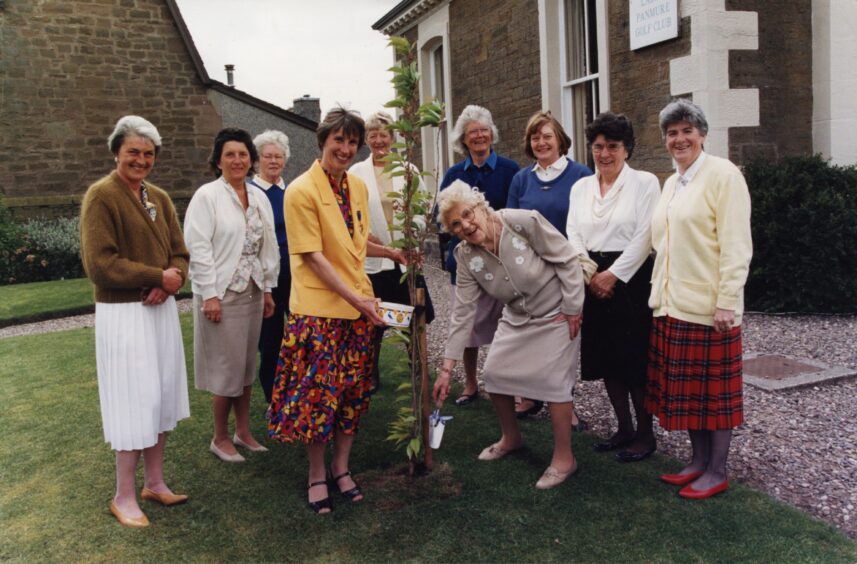 Mabel and Ann surrounded by other members of the committee after the tree is planted