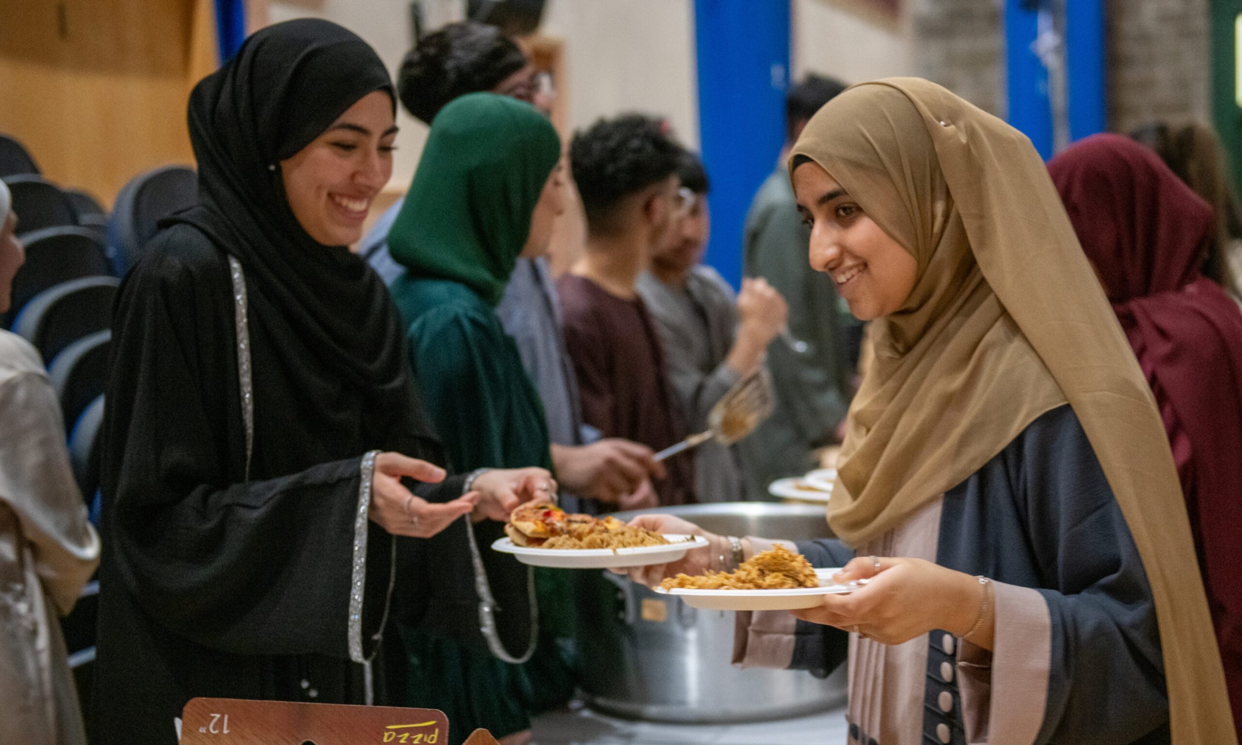 Guests and pupils enjoy the food at Morgan Academy's Iftar party.