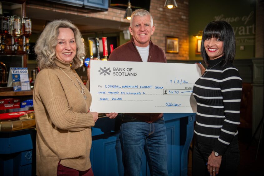 Karen Thomson from the Cornhill MacMillan Support Group with Jim and Yvonne Weir and a giant cheque at the King James pub in perth