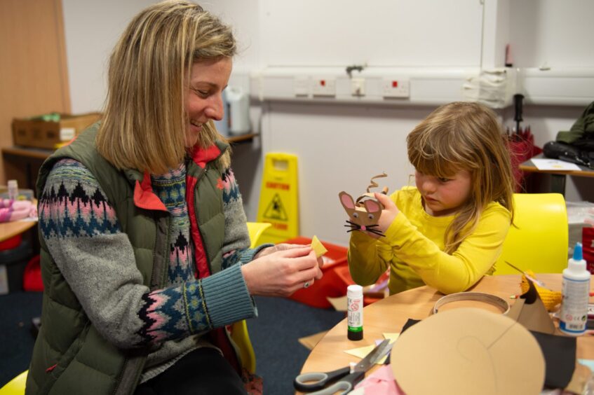 Woman and little girl making paper mouse at the Kinross better Place to Live fair