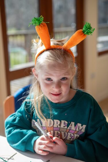 Ivy Whitaker, young blonde girl with headband with carrots sticking out of the top at craft event in Kenmore