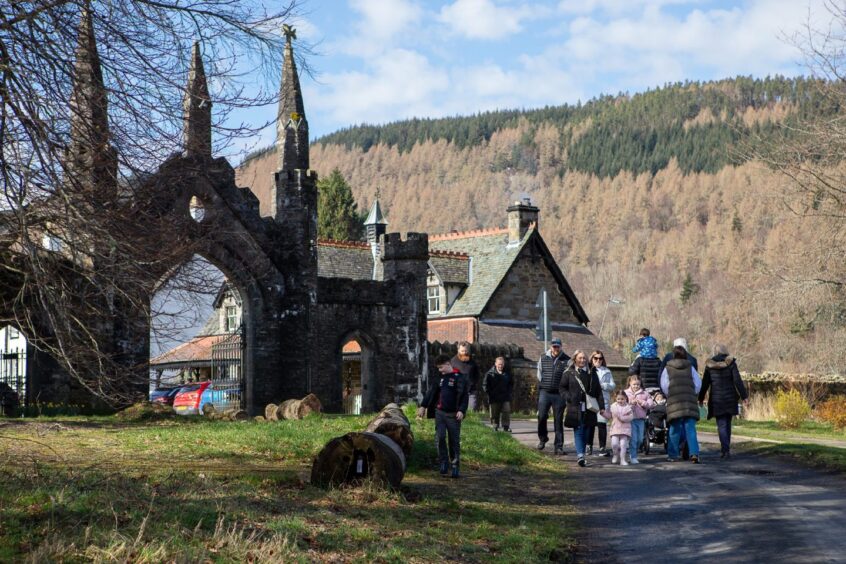 People walking through village of Kenmore with distinctive stone gates