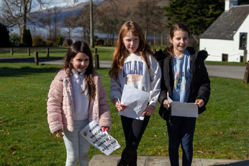 Hally Smith, Zoe Mulvaney and Milly Smith, three primary school age children holding treasure hunt clues in Kenmore