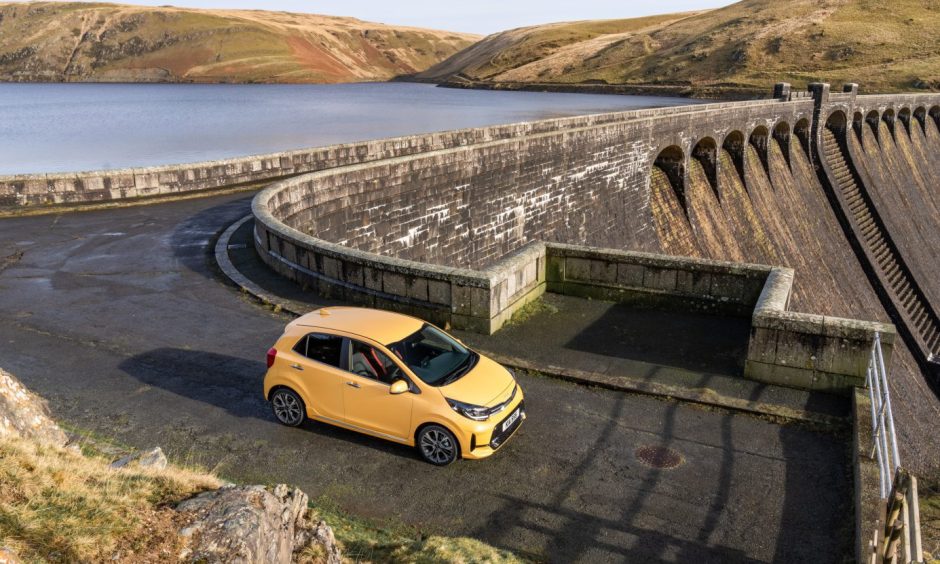 The Picanto on a road that crosses a dam.