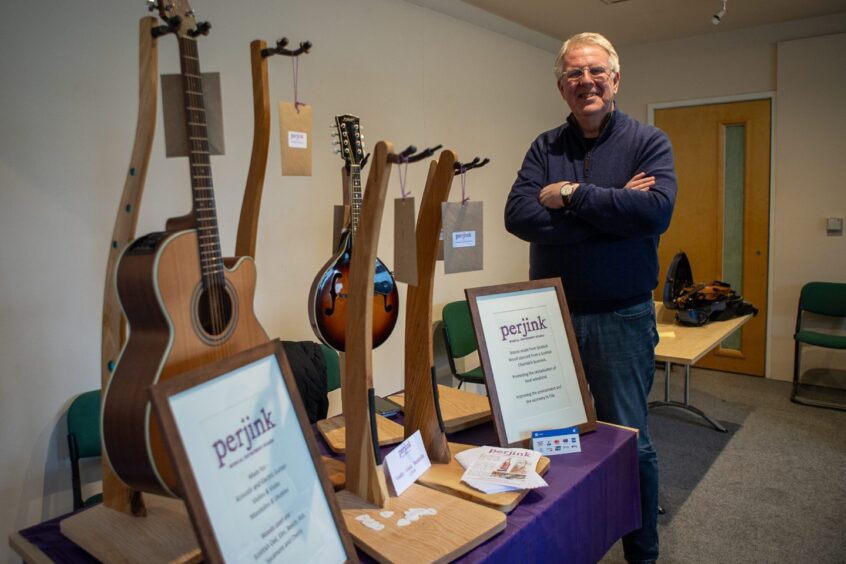 Jim Gillies from Perjink Musical Instrument Stands standing next to display of his work