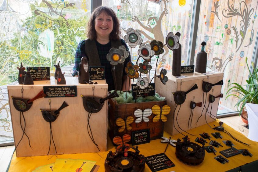 Smiling Fiona Guinan beside some of her pottery creations