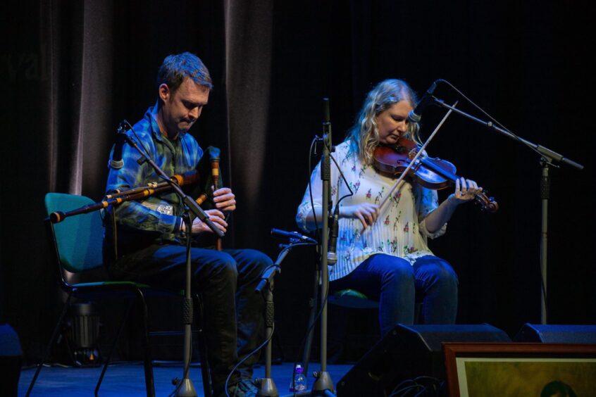 Finn Moore and Sarah Hoy playing fiddles on stage at Birnam Arts