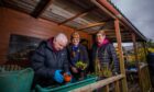 Amanda James, centre, at the Kinross Potager community garden alongside Peter Scott and his sister Fiona Leckie. Oeter is an elderly man potting flowers while the women look on.