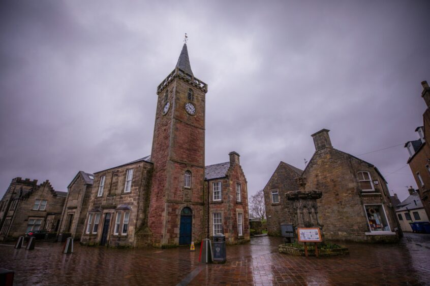 General view of old square in Kinross, with town hall and fountain on a rainy day
