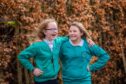 Pupils Maya Tyrrell and Ellie Sutherland laughing heartily with their arms around one another