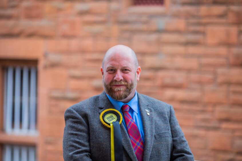 Tom McEwan wearing SNP rosette at an election count