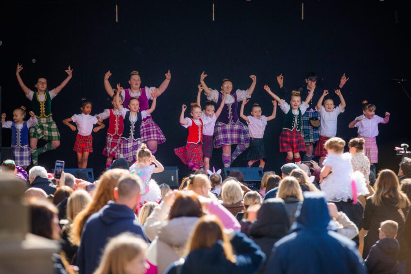 Scottish highland dancers watched by a large crowd on stage outside new Perth Museum on opening day