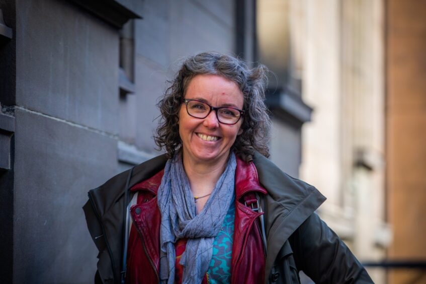 Caroline Buchan with glasses, greying hair and big smile