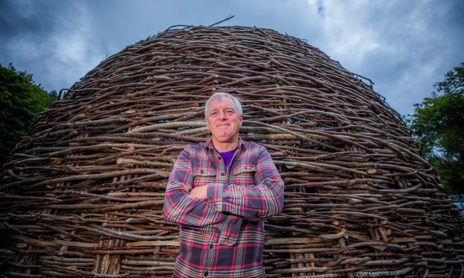 Mike Benson arms folded in front of timber building at the new site.