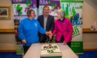 Pat Scotland, Geoff Brown and Jennifer Valentine laughing as they cut the cake at the Riding for the Disabled Perthshire celebration