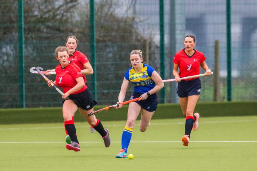University of Dundee in Red vs Abertay University in blue and yellow in the Women's Hockey.