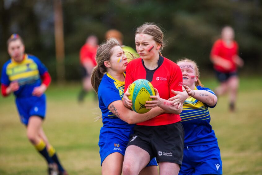 Faces show grit and determination as Abertay tries to tackle Dundee. 