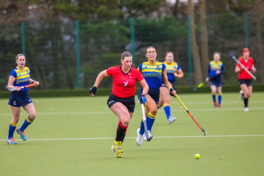 A player from Abertay University hot on the heels of a Dundee University player during the women's hockey Varsity Challenge. 