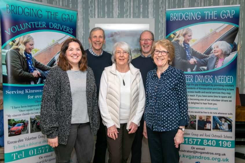 Group of five people standing in front of banner advertising the Kinross-shire Volunteer Group & Rural Outreach Scheme