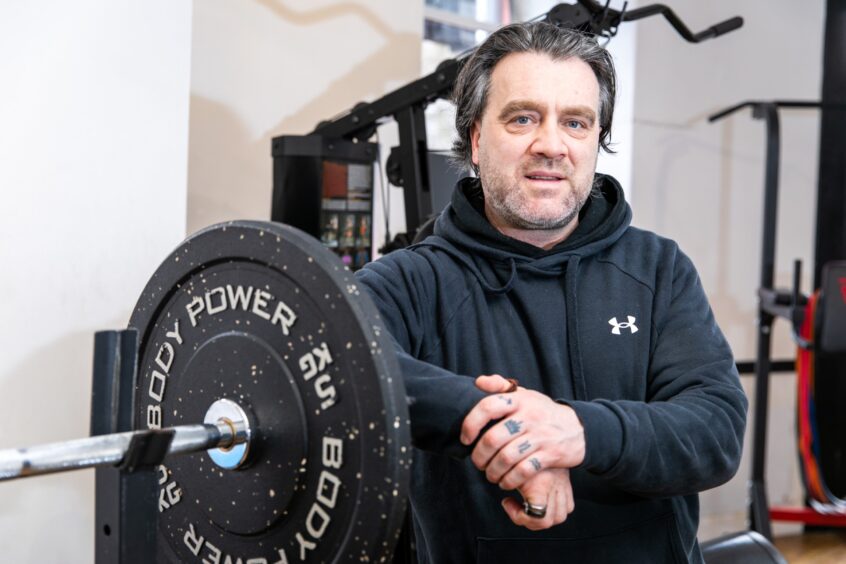 Murray McDowell standing next to weights at his Routine Health and Fitness Gym at Bridgend, Perth