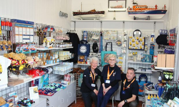 Arbroath lifeboat volunteers Susan Ruark, Mary Gerrard and David Anderson in the RNLI shop at the town station. Image: Wallace Ferrier
