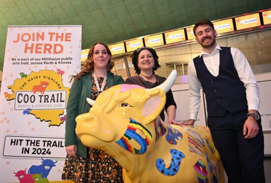 Hayley Smith, Rio Moore and Callum Penman standing next to a Hairy Highland Coo sculpture in Perth Concert Hall