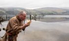 Scottish Crannog Centre tour guide John McGarry making fire on the new site at Dalerb. on the north side of Loch Tay.