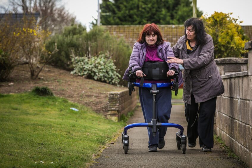 Becky and Caroline on their daily walk. Becky is using a walking frame with wheels