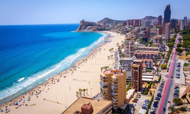 Poniente beach of Benidorm in summer seen from the heights of a skyscraper with the beach, the sea and other buildings of hotels and apartments.