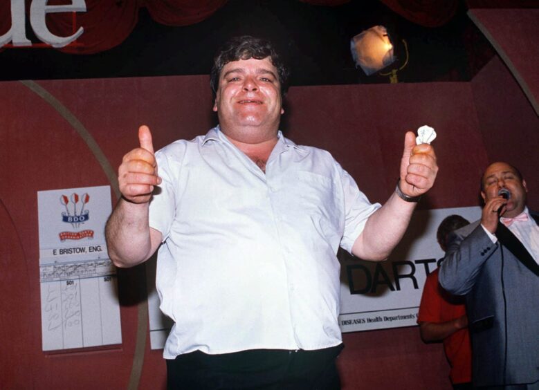 Jocky Wilson celebrates with two thumbs up, and darts still in his hand, after winning the 1989 world crown at Lakeside.