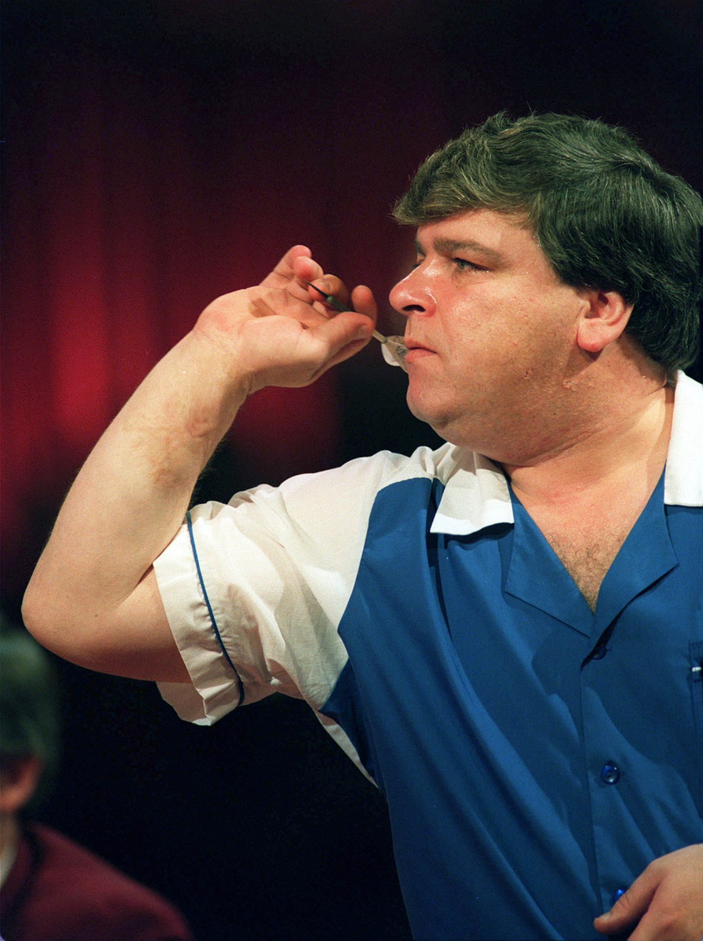 Jocky Wilson at the oche in blue and white shirt