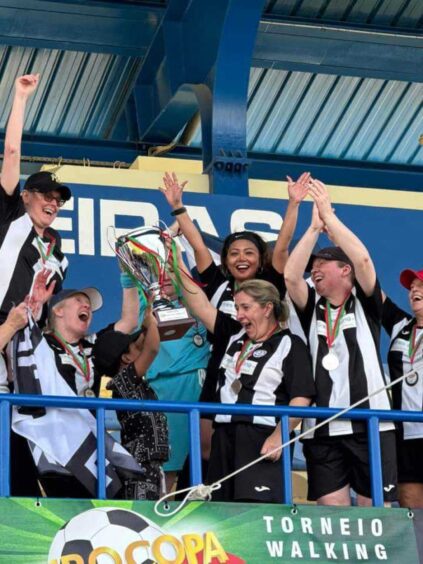 Jeanfield Swifts women walking football players celebrating after being presented with trophy