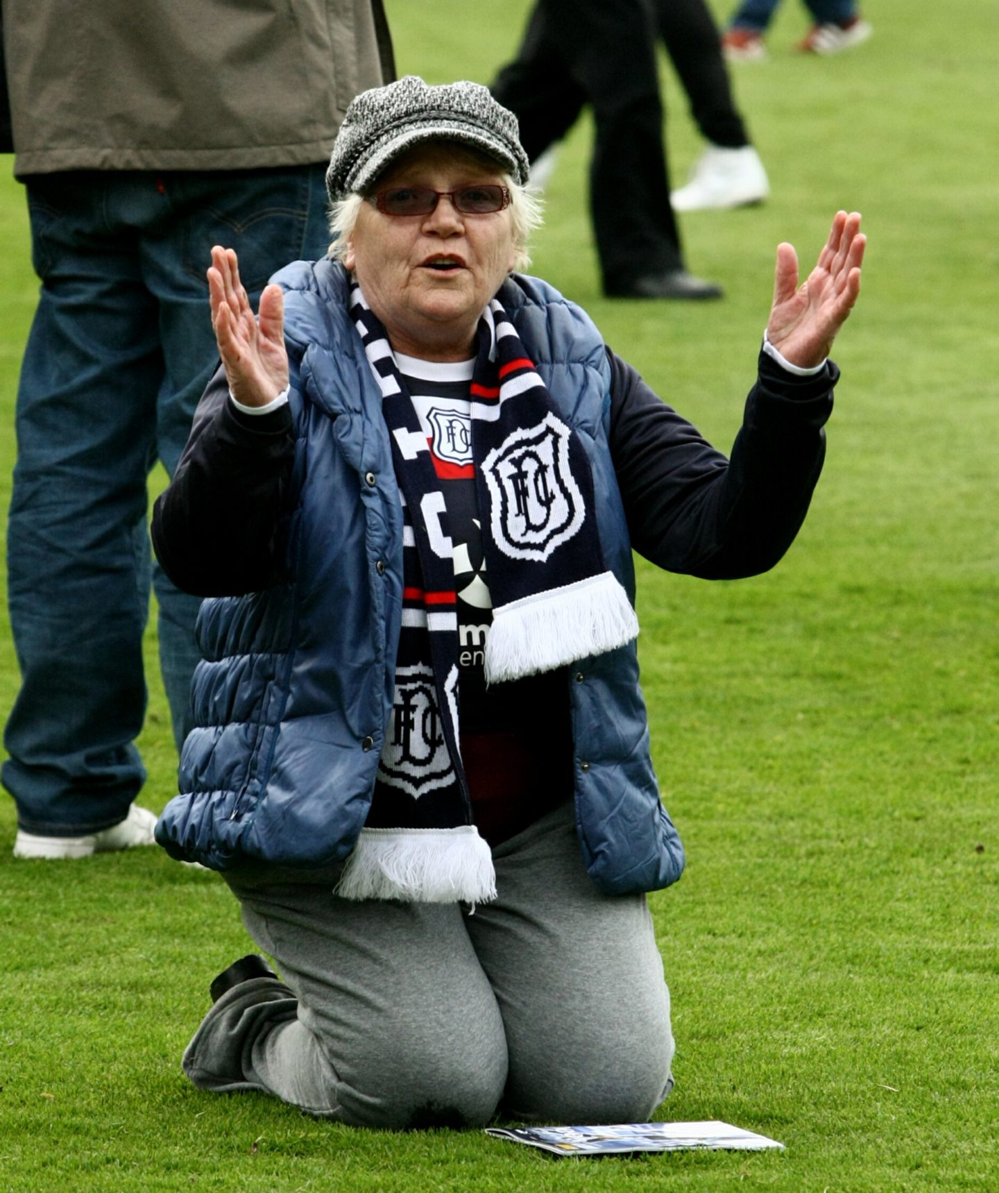 A Dundee supporter bows down to her heroes on the pitch. 