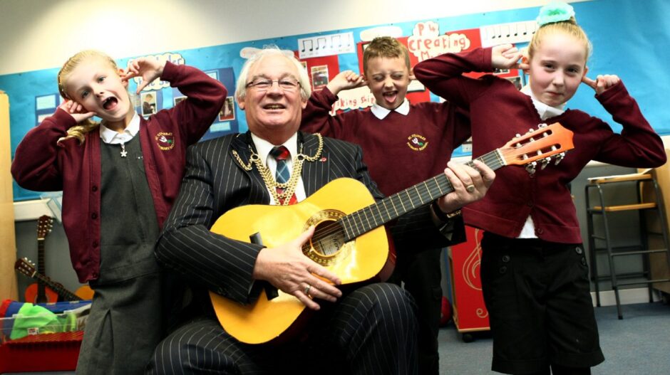 Provost Leishman launches Fife Festival of Music in Cupar in 2014 by playing a guitar in a classroom for some pupils