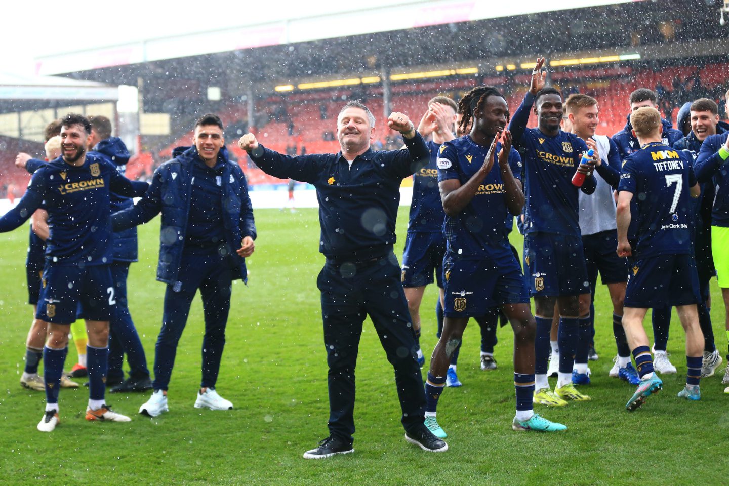 Manager Tony Docherty celebrates with his players in front of the Dundee fans. Image: Shutterstock