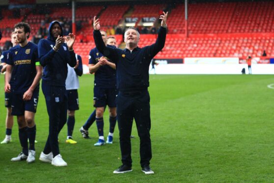 Dundee boss Tony Docherty celebrates with fans at Pittodrie. Image: Shutterstock