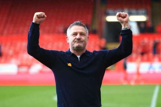 Dundee manager Tony Docherty celebrates in front of travelling fans at Aberdeen. Image: Shutterstock