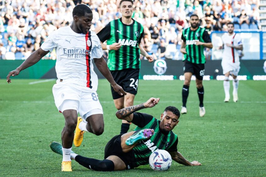 Yunus Musah in action for AC Milan as he is tackled during a game against Sassuolo.