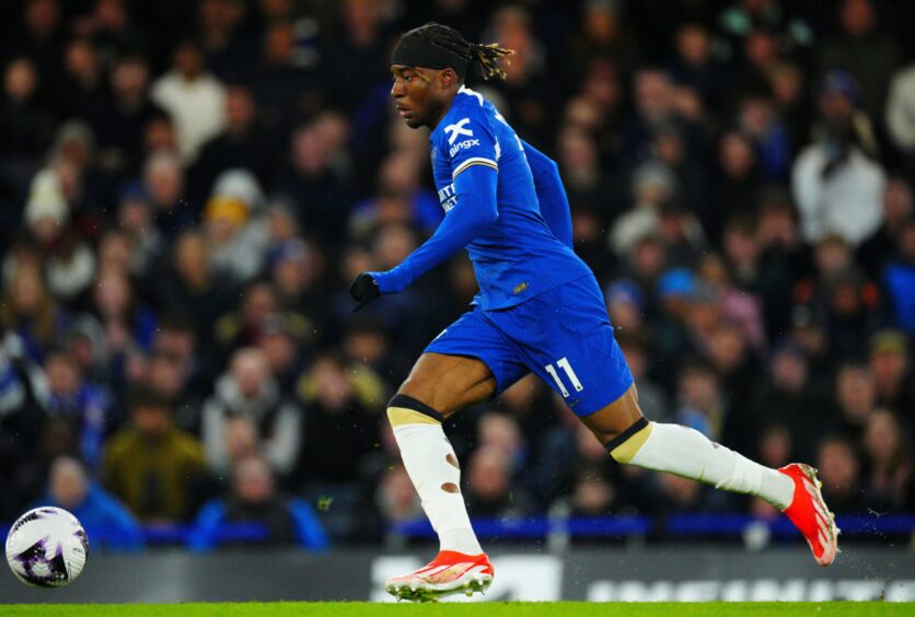 Noni Madueke in full flight for Chelsea with the ball at his feet.