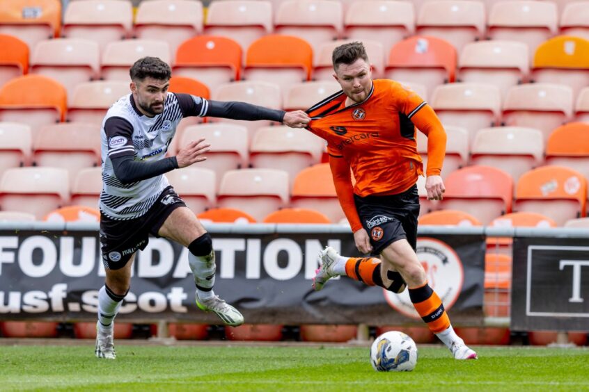 Dundee United's Glenn Middleton is hauled back as he seeks to make headway