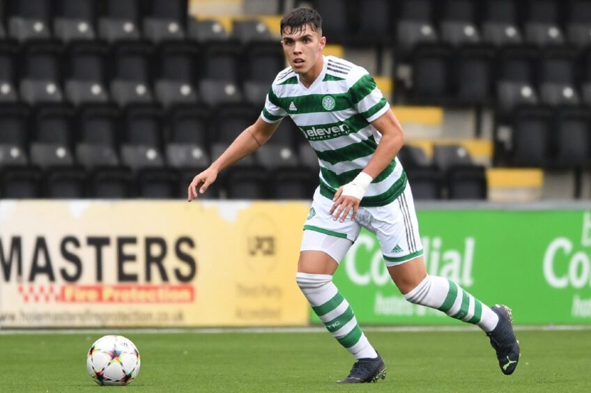 Dylan Corr, playing for Celtic, looks into the distance with the ball at his feet.